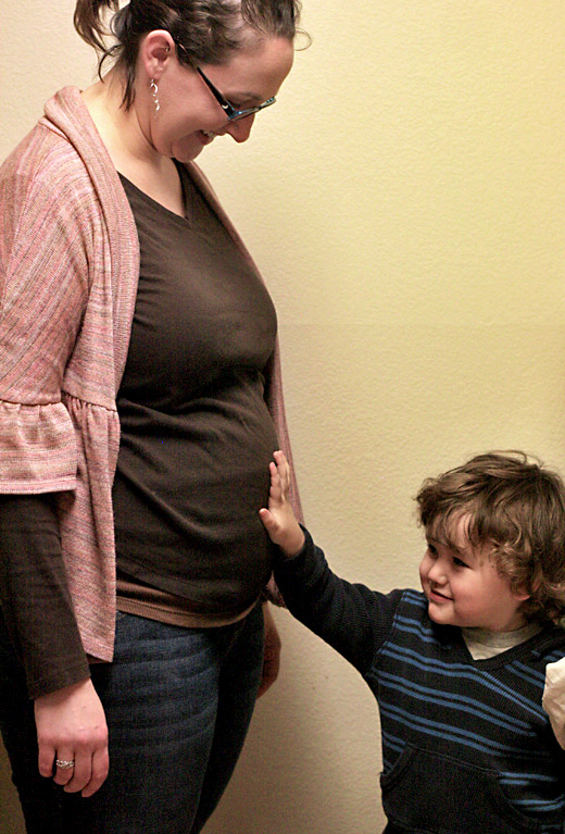 mama and son touching pregnant belly bump 18 weeks