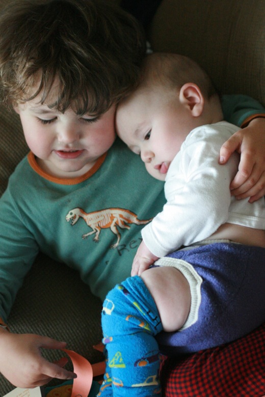 brothers snuggling — preschooler with baby on lap