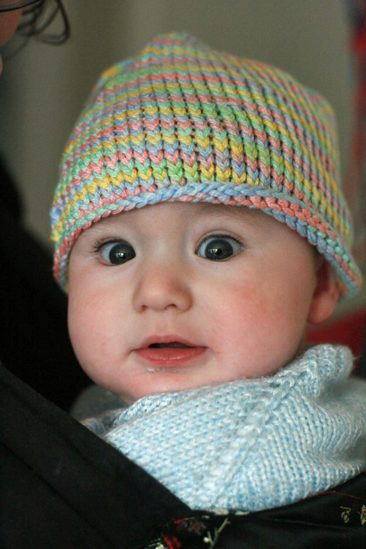 baby bundled up for the cold outside with wide dark blue eyes