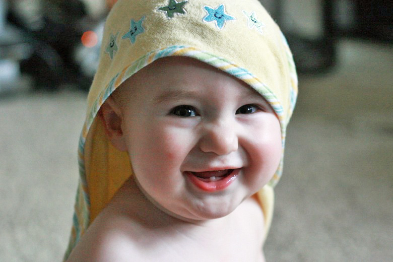 baby smiling in hooded towel
