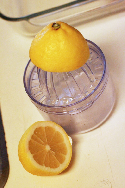squeezing juice from a lemon - homemade ricotta cheese recipe