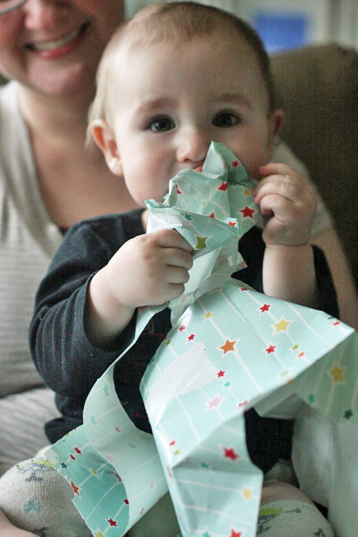 baby eating wrapping paper at birthday