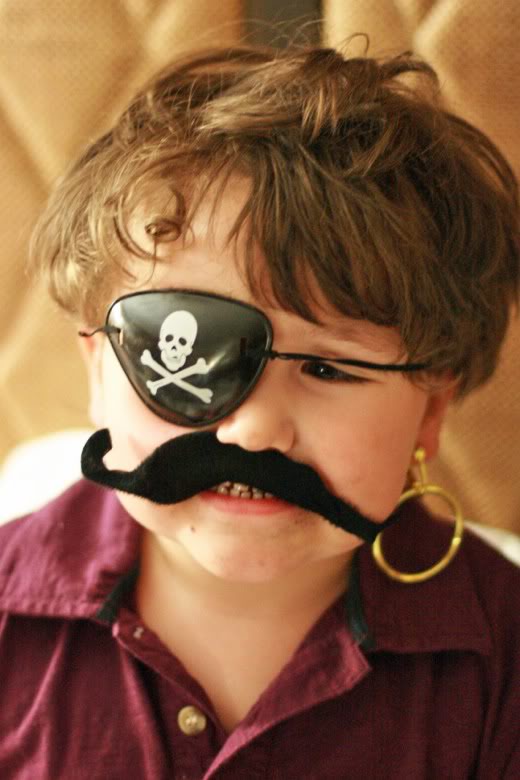 Boy in pirate costume mustache eyepatch and earring