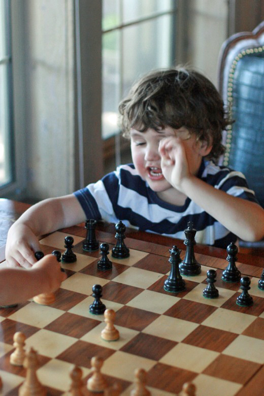 boy playing chess with cousin