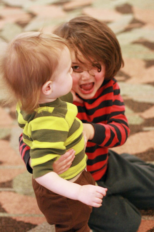 two happy boys attacking each other at the mall - brothers siblings