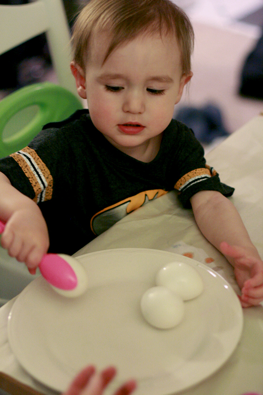 toddler transferring dyed eggs to plate - Easter 2013 holidays montessori