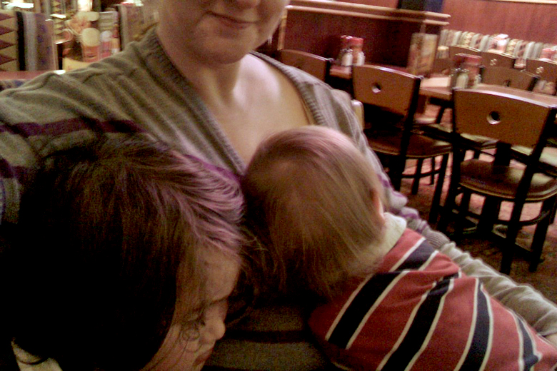 sick boys snuggling with mom at restaurant