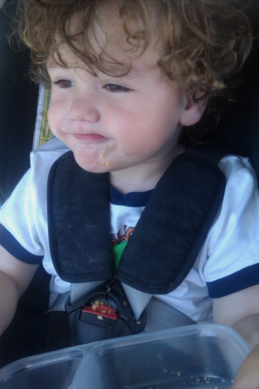 boy in car seat eating snacks