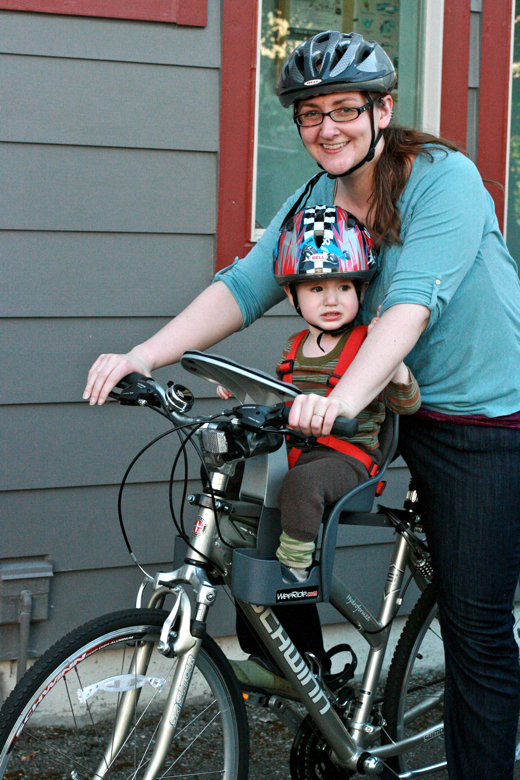 mom and toddler boy in bike helmets on bike with weeride seat - biking outdoors