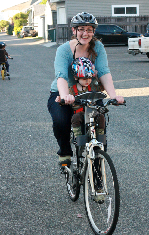mom and toddler boy in bike helmets on bike with weeride seat - biking outdoors