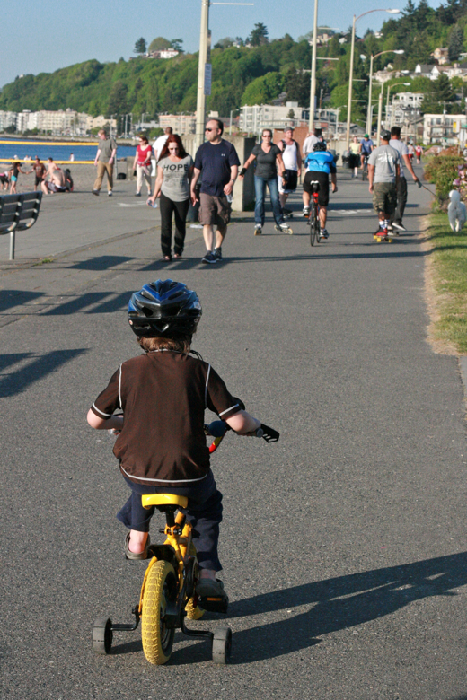 boy riding bike in helmet with training wheels on beach - mikko m5yo biking outdoors