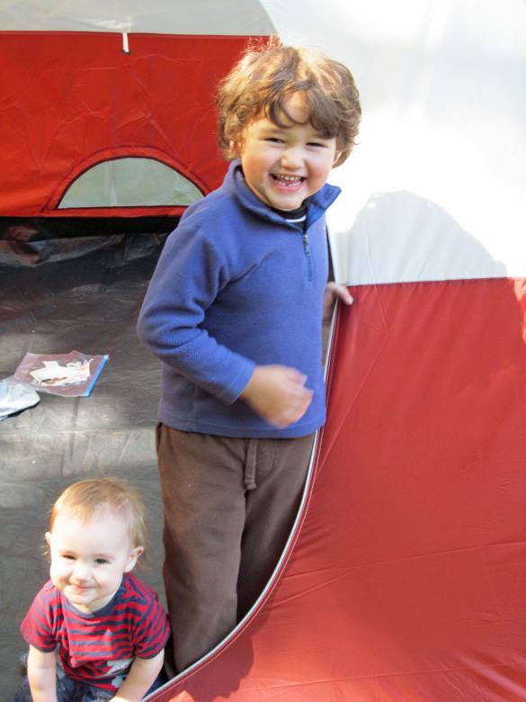 boys smiling in tent opening in family camping