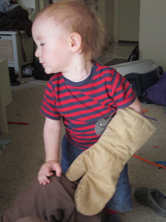 toddler with oven mitt