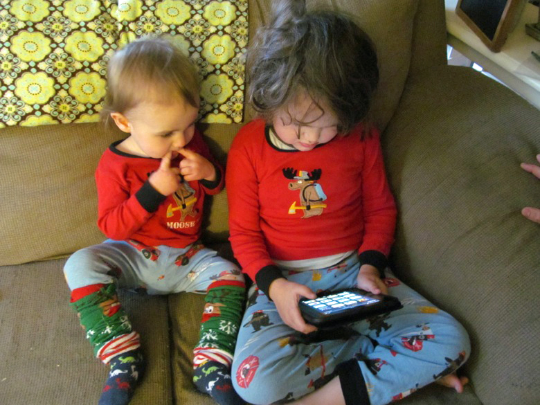 boys on couch on christmas morning opening kindle angry birds app &mdash;