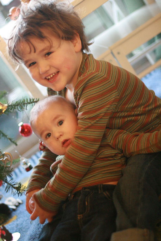 baby and boy at Christmas tree
