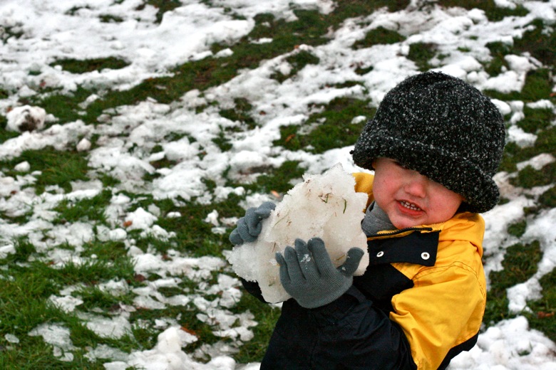 boy picking up snowball in winter outdoors in Seattle