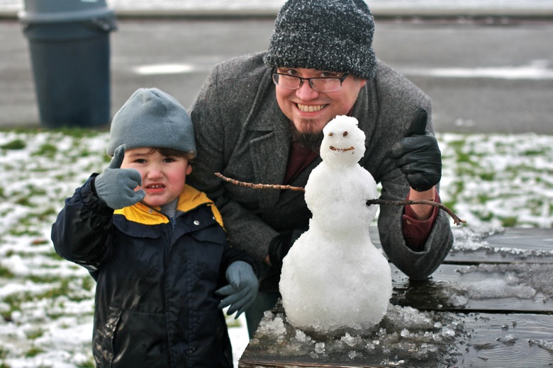 building mini snowman outdoors Seattle — dad and son
