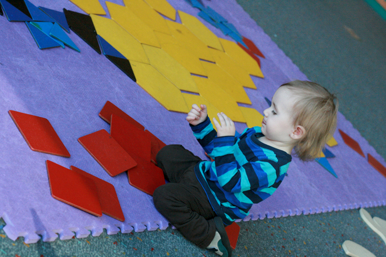 toddler putting together giant floor puzzle - pacific science center outing seattle unschooling