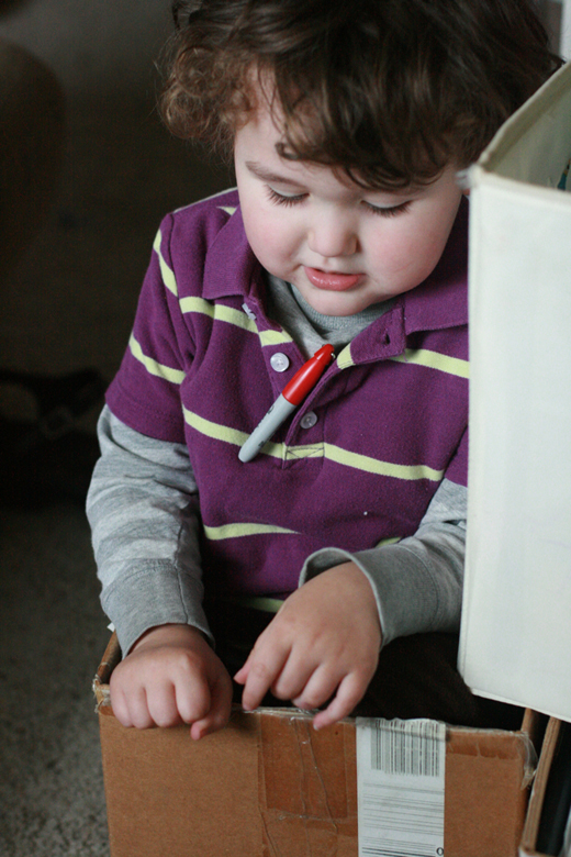 boy sitting in box with sharpie marker