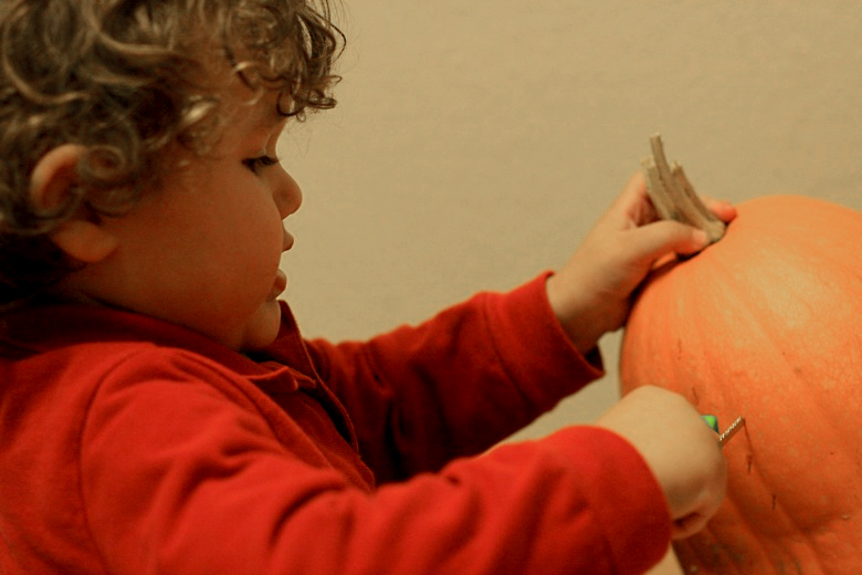 boy beginning to carve pumpkin