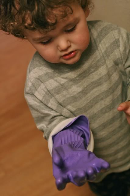toddler wearing big purple dish glove