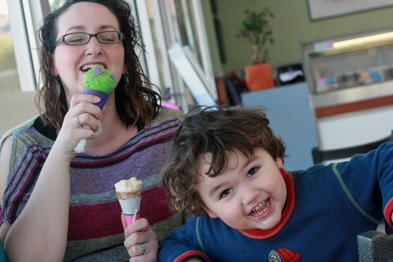 mom and three-year-old son eating birthday ice cream cones together