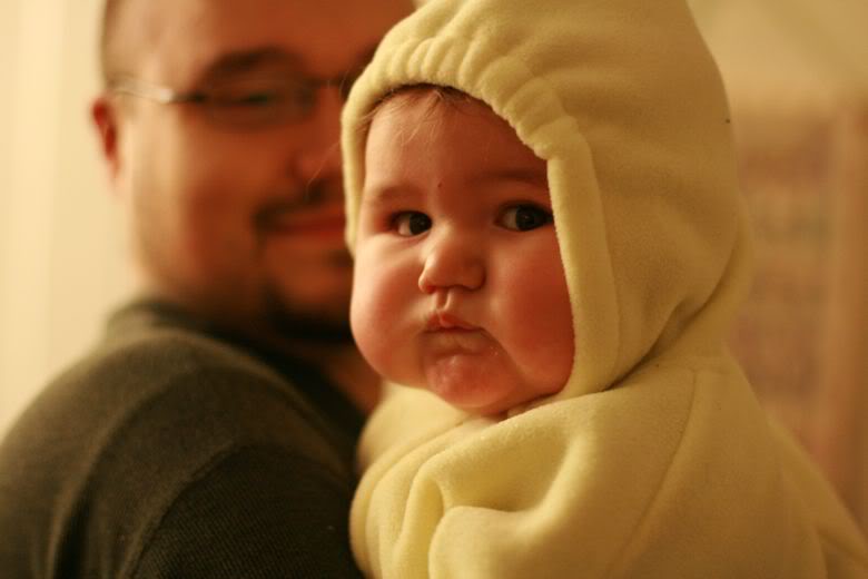 baby in a snowsuit held by father