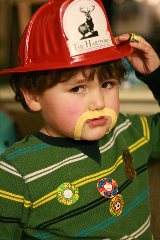 serious boy wearing mustache and firefighter hat