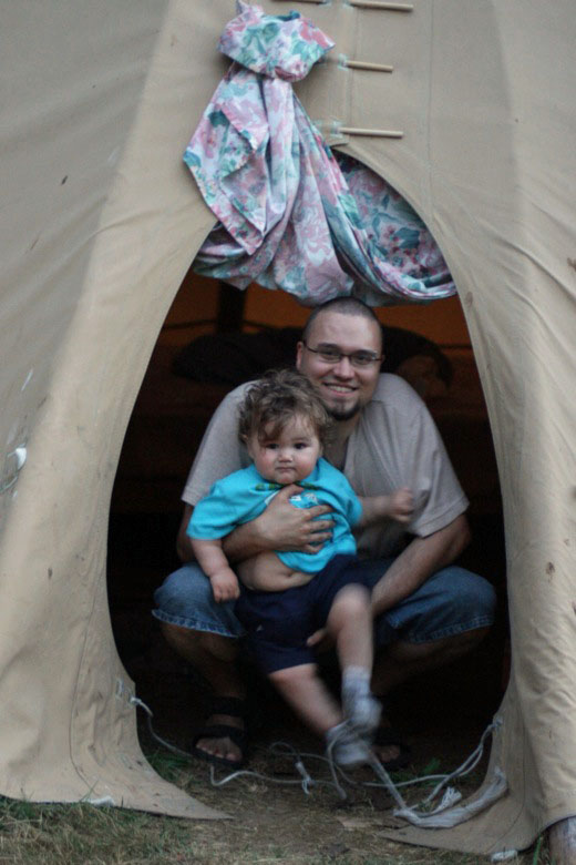 dad and boy in teepee while camping