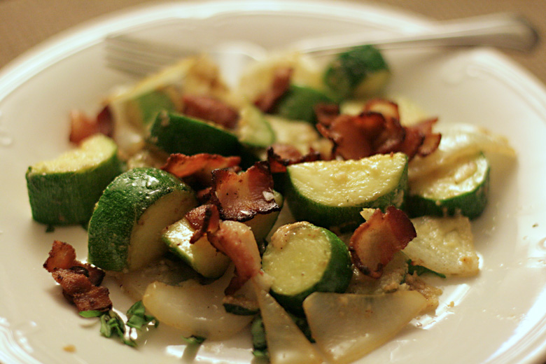 zucchini from garden in meal on plate with onion and bacon